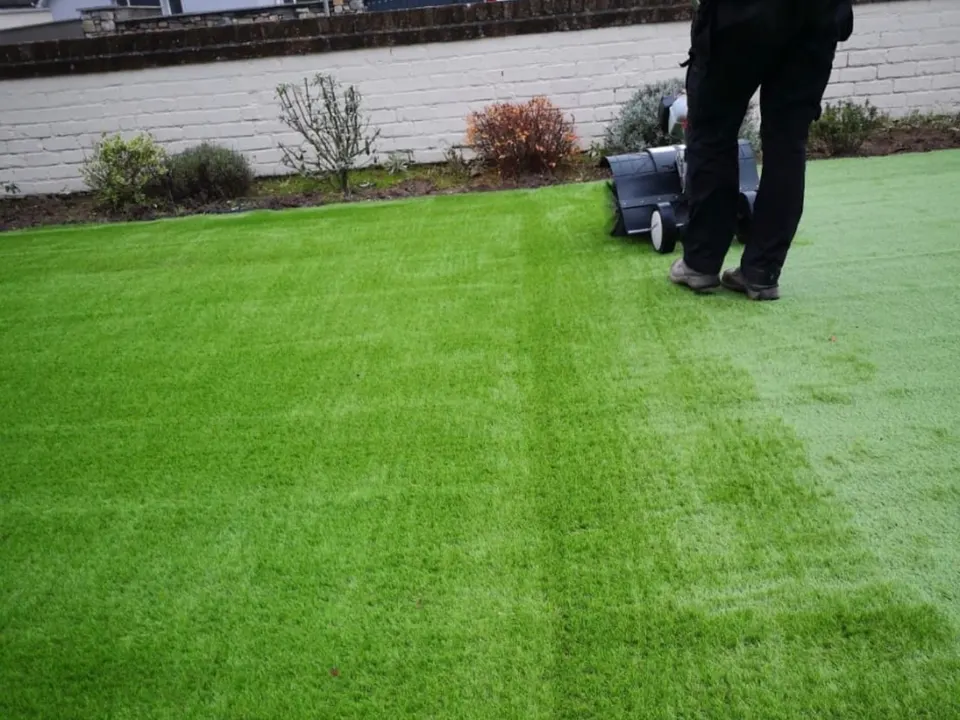Power brushing a newly installed artificial lawn