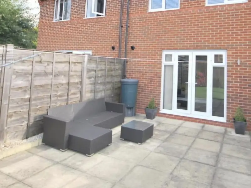 Before: tired flagged patio replaced with a porcelain patio and block paving