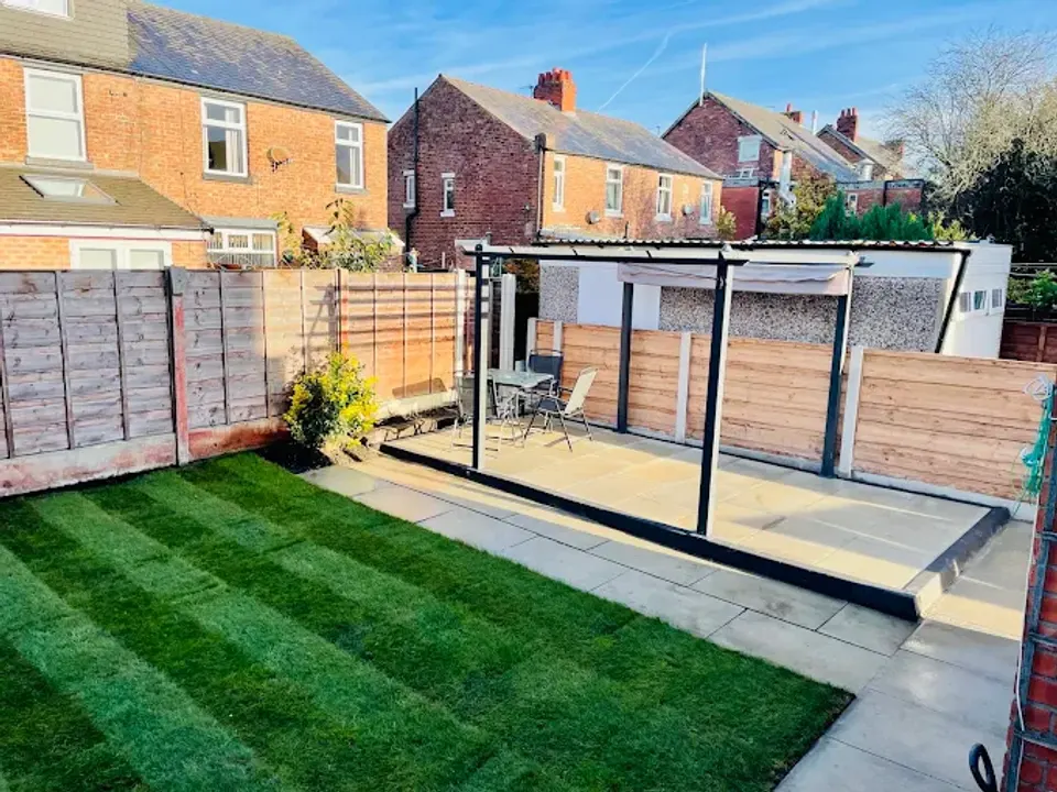 Completed garden transformation with porcelain patio, pergola and striped lawn