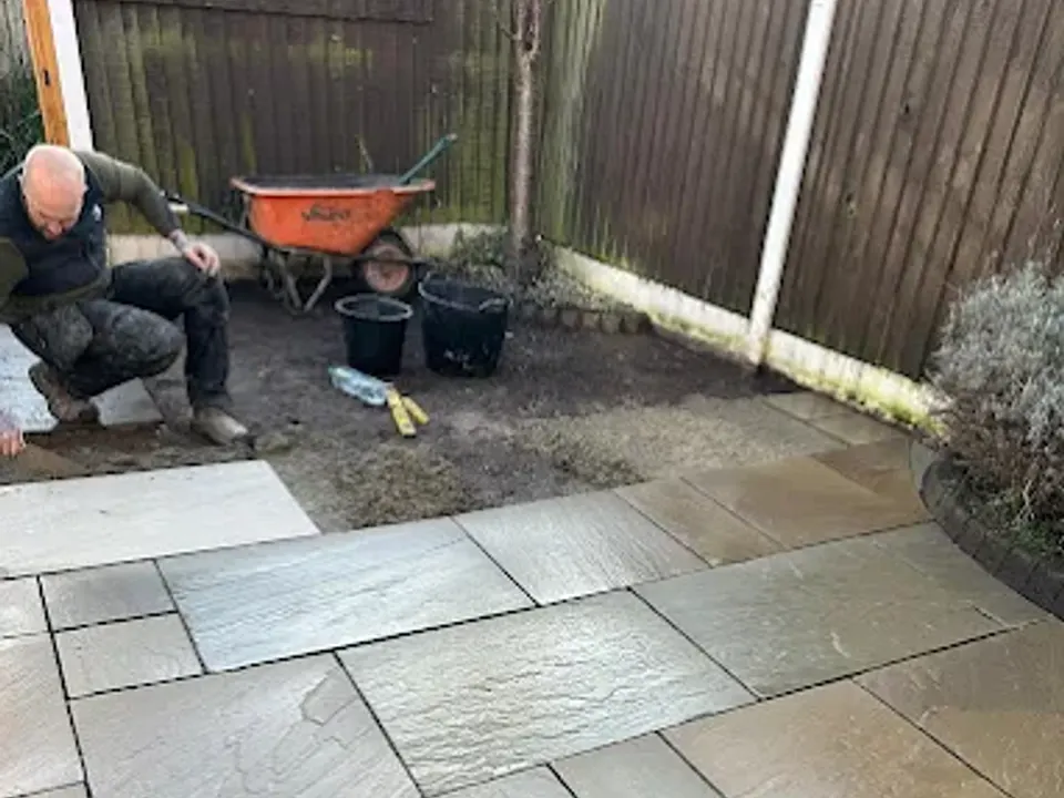 One of the Barrow Landscaping team laying a sandstone patio