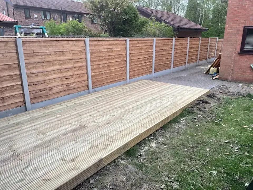 New timber deck built along a close board fence